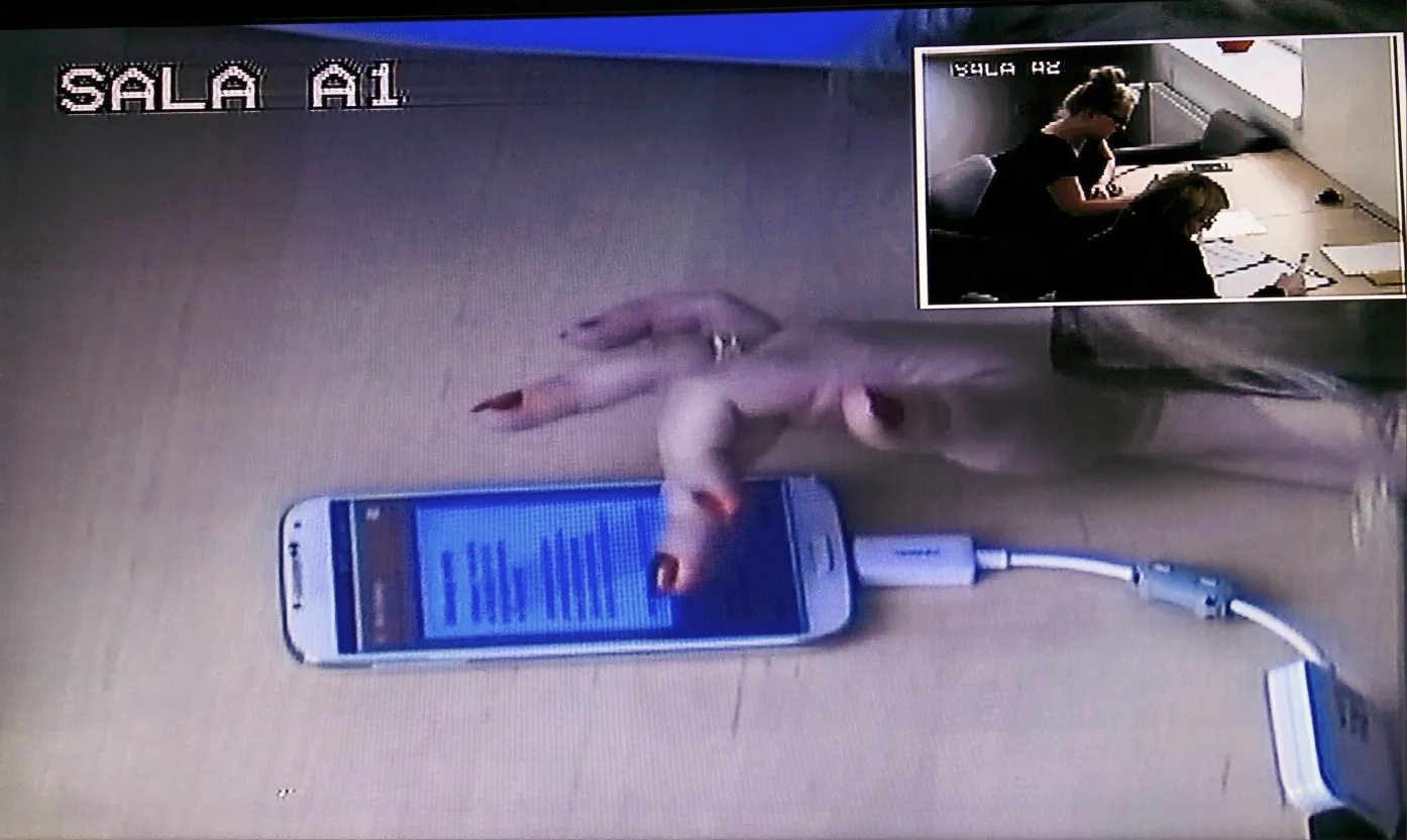 A phone on a desk during a user test, filmed by the lab camera
